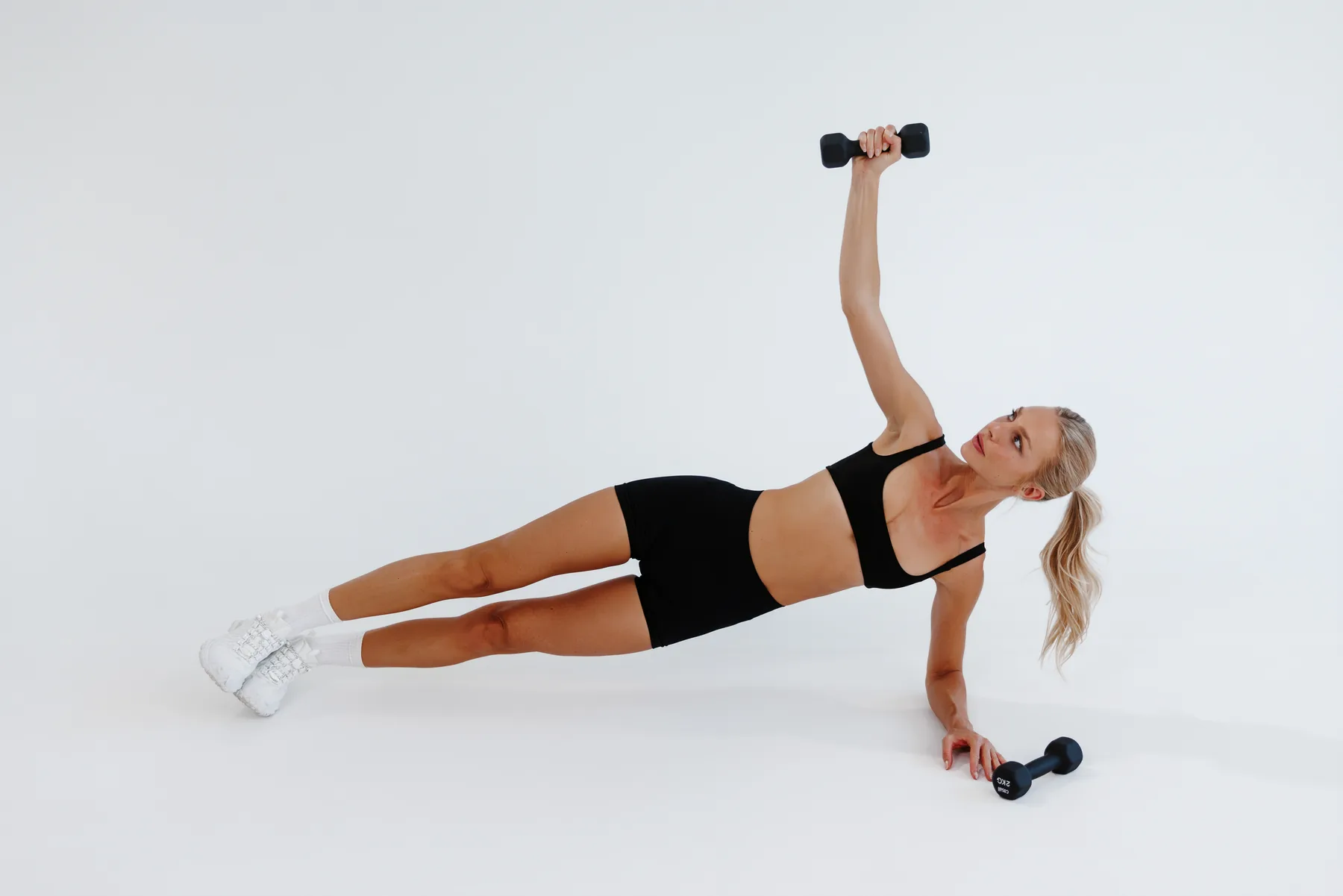 Angela holding a side plank with a dumbbell