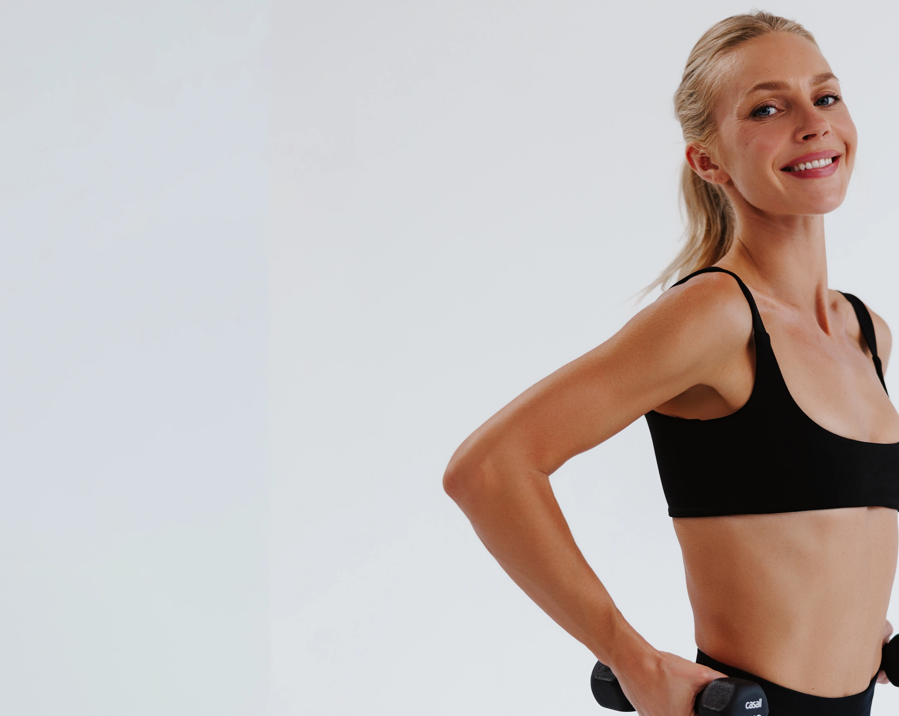Angela smiling while training with dumbbells